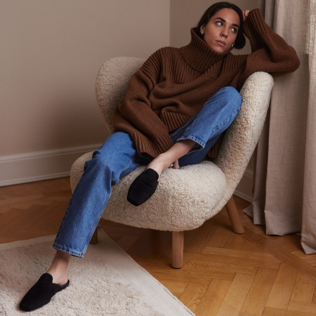 Woman wearing black suede slippers